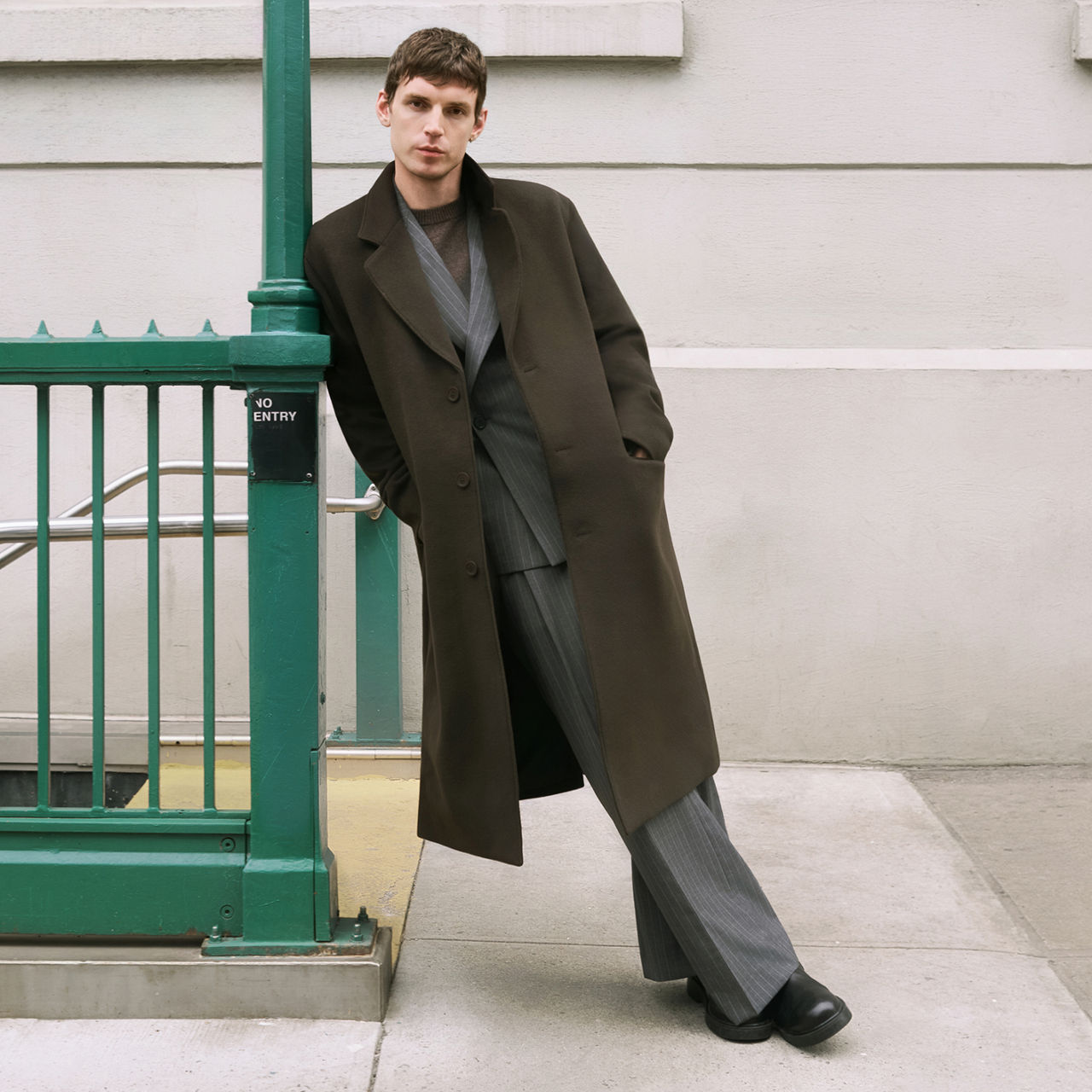 A man in a dark brown top coat over a casual gray suit. Falls top trends, men.