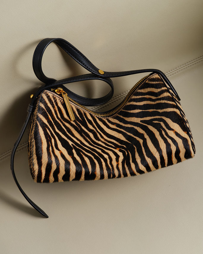 A tiger stripe handbag with black strap. Shop animal print.