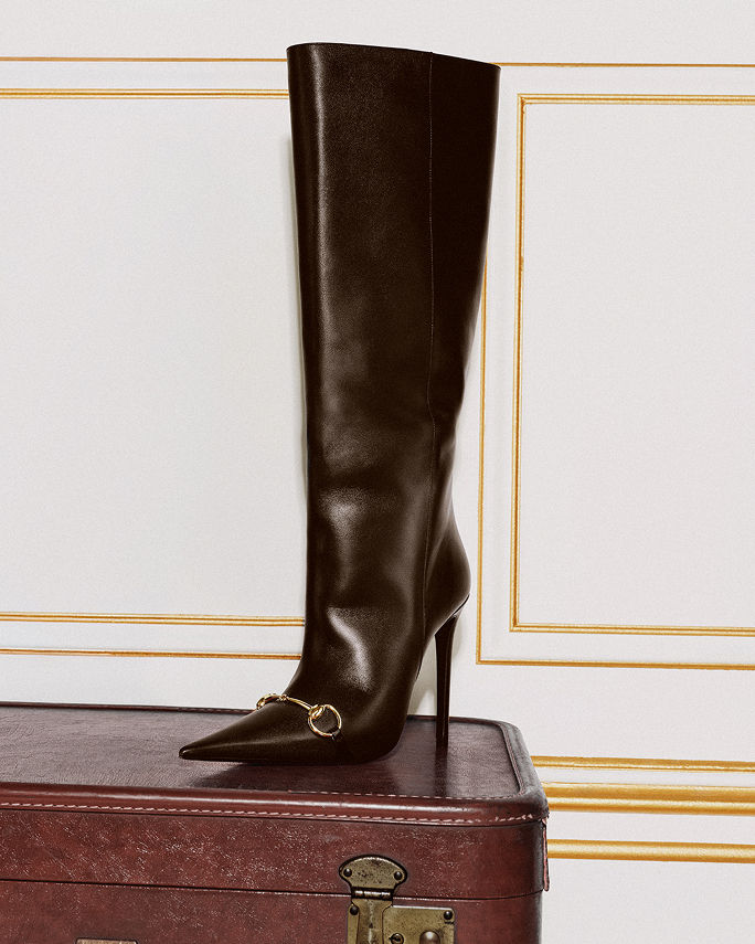 A single black tall boot with stiletto heel. Shop knee high boots.