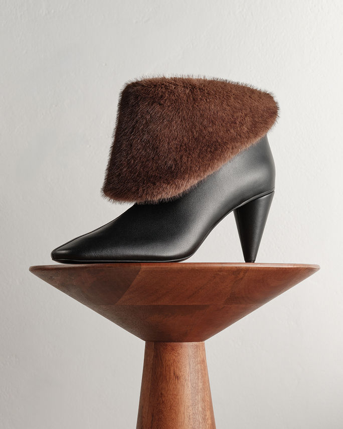 A black boot with brown faux fur top. Shop shearling & faux fur.