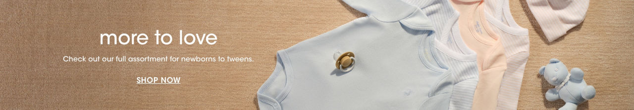 1 photo, of four pastel colored onesies laid in a row on a beige carpet, a pacifier on top and a small blue bear next to them.