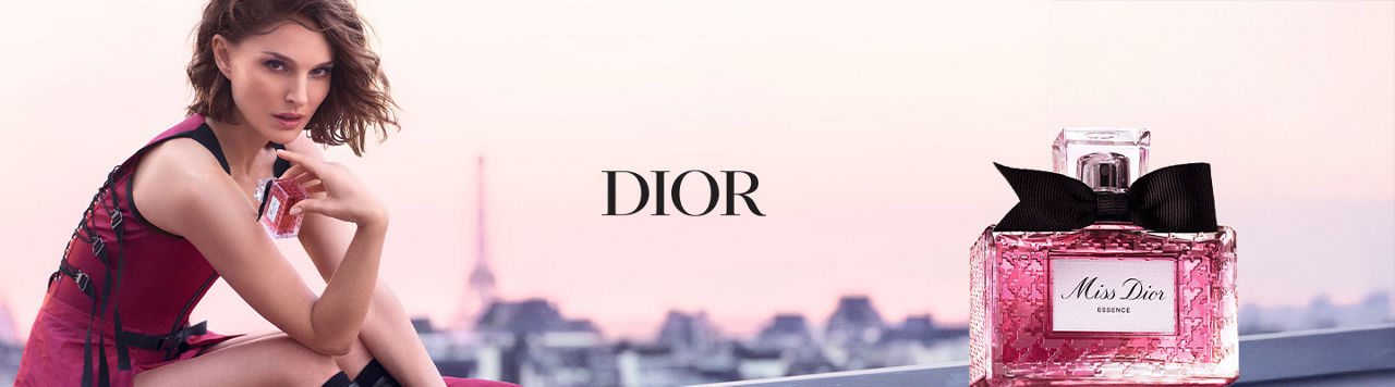Dior. Actress Natalie Portman in a pink dress, the Eiffel Tower blurred in the background and a bottle of Miss Dior in the foreground.