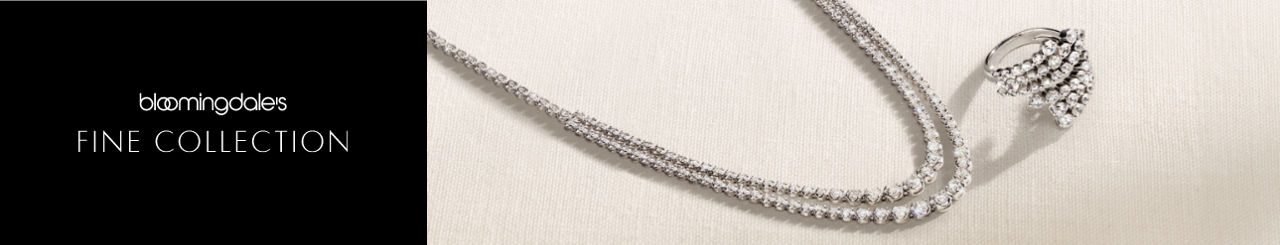 1 photo, of a sparkling two-tier diamond tennis necklace and a bypass diamond ring on a mottled green background.