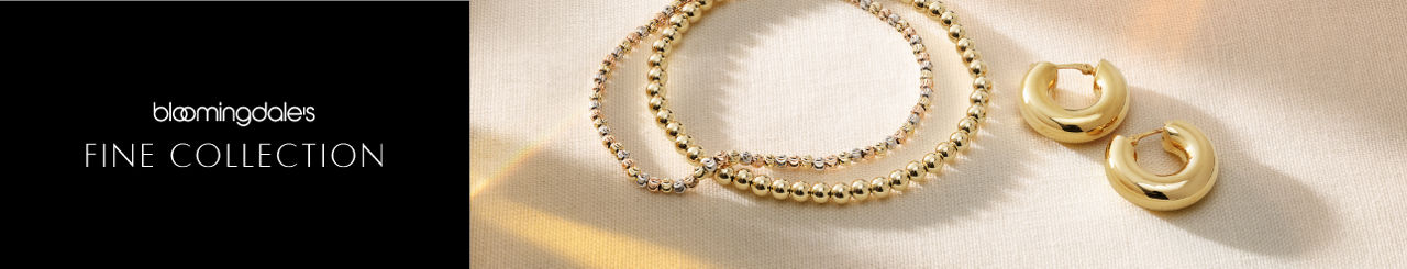 1 photo, of two gold bead necklaces atop each other next to a pair of gold huggie hoop earrings on a cream linen tablecloth.