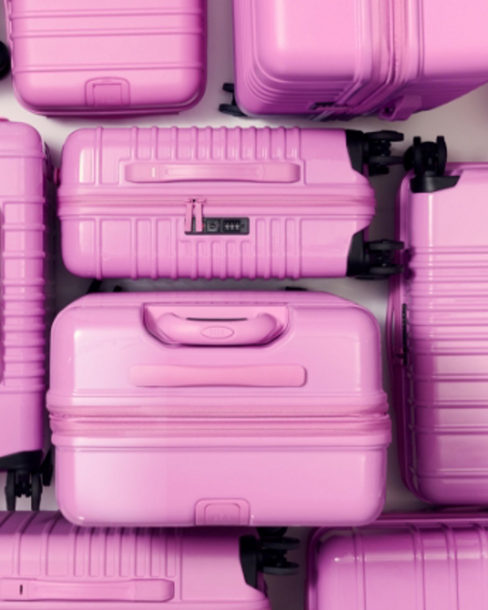 1 photo of an overhead shot of multiple pink Beis luggage arranged in a square shape.