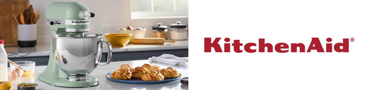 A KitchenAid mixer in mint green with a stainless steel bowl on a kitchen countertop.