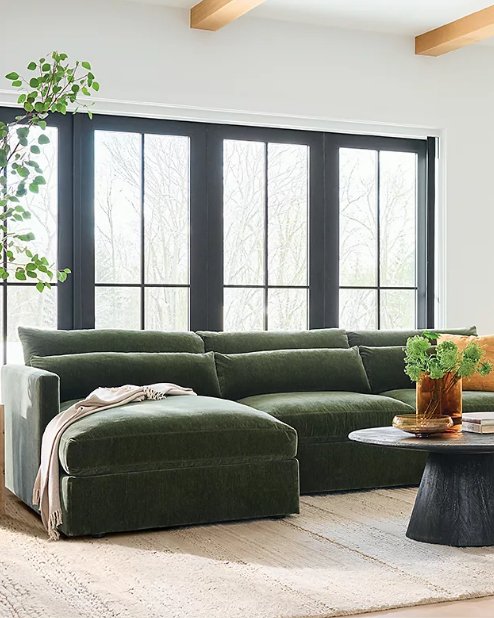 A green sectional sofa in a living room setting.